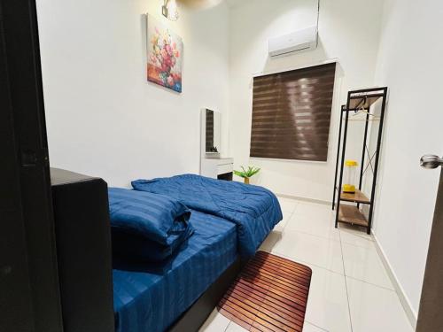 a bedroom with a blue bed and a window at Ethereal Ipoh Homestay in Ipoh