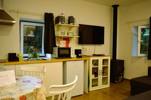 a kitchen with a counter with a table and a tv at Moinho do Zorrão in Manteigas