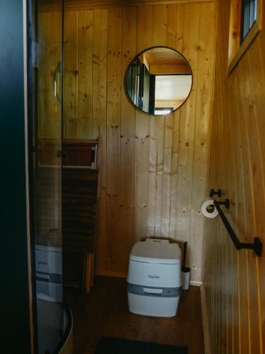 a small bathroom with a toilet and a mirror at Tiny Glamp - Kontejner Šikmina in Dolní Moravice