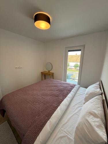 a bedroom with a bed and a window at Dream Premium Apartman in Mosonmagyaróvár