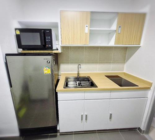 a small kitchen with a refrigerator and a microwave at Supalai Park Phuket City 2 bedrooms for rent in Phuket