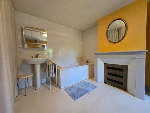 a bathroom with a tub and a sink and a mirror at Campagne normande en famille in Verneuil d’Avre et d’Iton