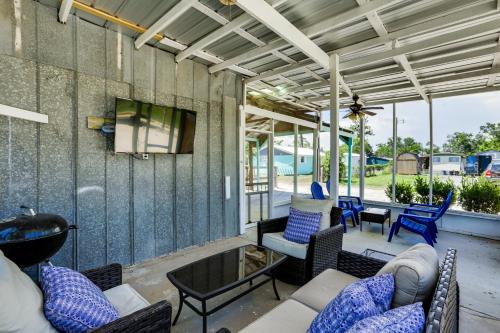 a screened in porch with furniture and a tv at Walk to Pier and River Dtwn Steinhatchee Escape! in Steinhatchee