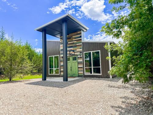 a small house with a green door on a gravel driveway at New Bison Cabin Hot Tub Air Hockey Pool Table in Purcell