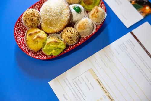 a plate of donuts on a table next to a paper at Porta Trapani rooms & suites in Erice