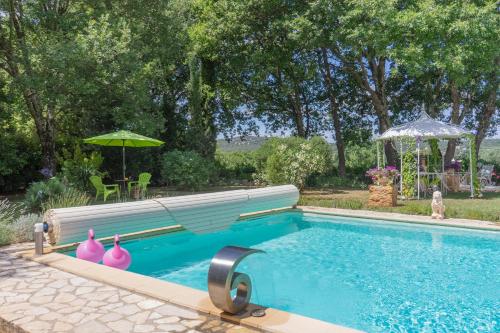 una piscina con una panchina e un ombrellone di Chambre d'Hôte Couguiolet - avec piscine a Foissac