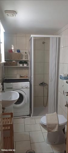 a bathroom with a washing machine and a sink at Maria's Studio No3 in Heraklion in Thérissos