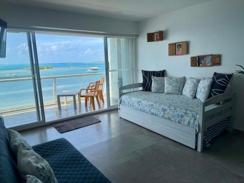 une chambre avec un lit et une vue sur l'océan dans l'établissement Apartamentos con playa privada y vista al mar, à San Andrés