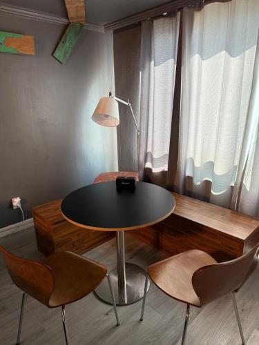 a table with two chairs and a lamp in a room at All New Diamond House in Busan