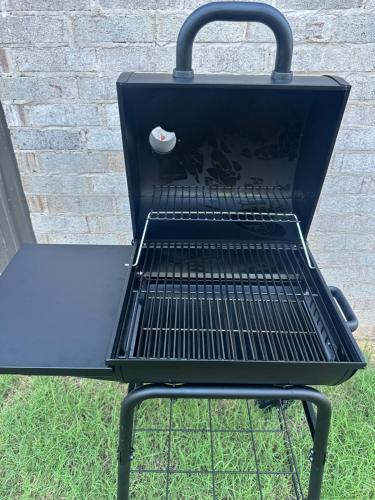 a black barbecue grill sitting next to a brick wall at New Bison Cabin Hot Tub Air Hockey Pool Table in Purcell