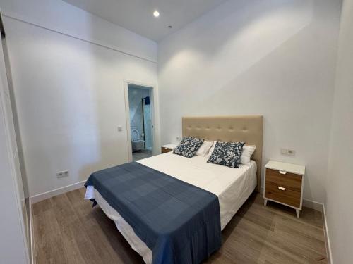 a small bedroom with a bed and a night stand at Canovas Nerja - Oasis de Capistrano in Nerja