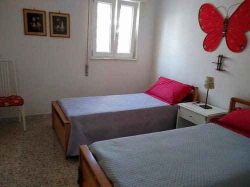 a bedroom with two beds and a butterfly on the wall at Appartamento Torre Santa Sabina vista mare in Torre Santa Sabina