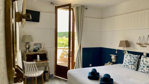 a bedroom with a bed and a sliding glass door at Hôtel Bien-Être Aux Cyprès de Marquay in Marquay