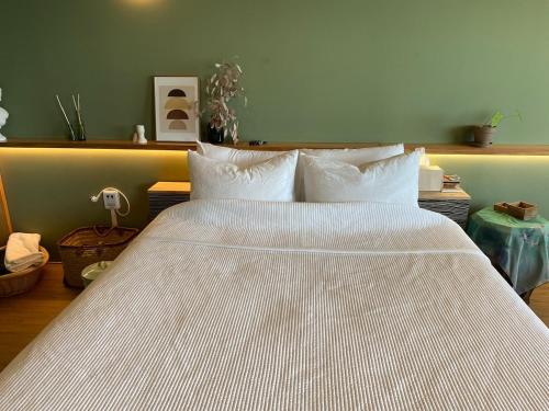 a bedroom with a large bed with white sheets at All New Diamond House in Busan