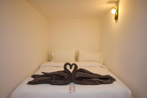 a bed with two towels in the shape of hearts at Sunway Grid Loft Suite by Nest Home【Olympic Size Pool】 in Kampong Pendas