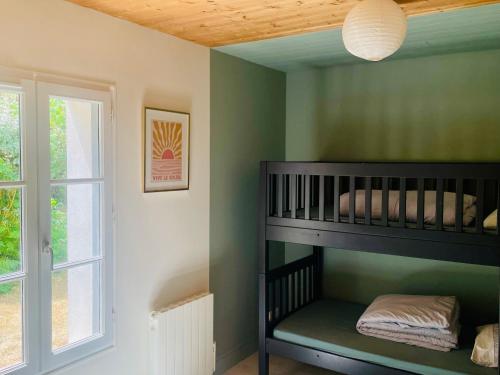 une chambre avec un lit superposé et une fenêtre dans l'établissement Maison vendéenne à 5 min du bord de mer, à Saint-Hilaire-la-Forêt