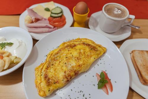 a table with plates of food and a cup of coffee at Hotel Uhland in Windhoek
