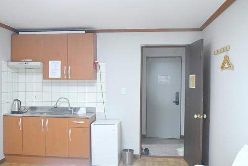 a small kitchen with a sink and a refrigerator at Sorak Hostel in Sokcho