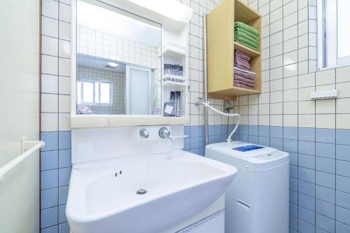 ein Badezimmer mit Waschbecken, Toilette und Spiegel in der Unterkunft わったー家あぱらぎ館 in Ishigaki-jima