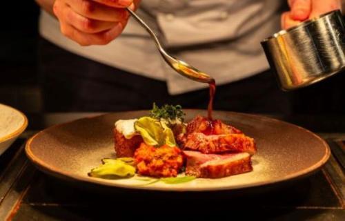 a person is eating food on a plate with a spoon at Casa Hotel in Chesterfield