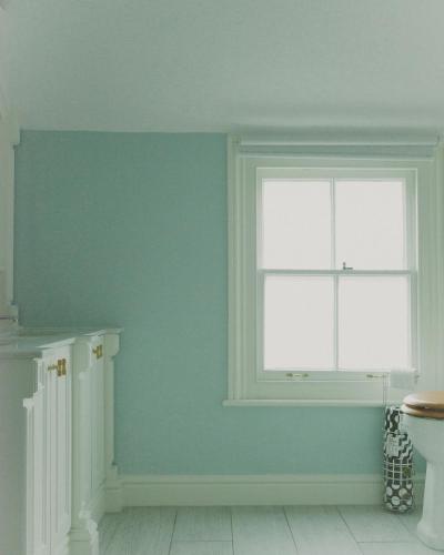 a bathroom with a blue wall and a window at Stylish Lewes Apartment - Gorgeous Views in Lewes