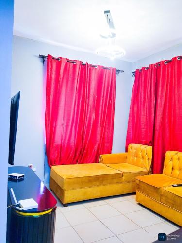 a living room with red curtains and a couch at granddaughter homes in Arusha