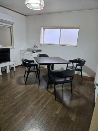 Una habitación con una mesa y sillas y un televisor. en U-neighbor 若比邻 伝法店, en Osaka