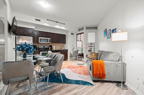 a living room and kitchen with a couch and a table at Superior 1Bd & DEN Apartment with Balcony in Toronto