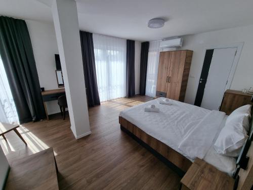 a bedroom with a bed and a desk in it at LUX - Rooms Apartments in Struga