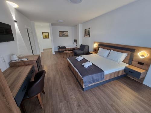 a bedroom with a large bed and a living room at LUX - Rooms Apartments in Struga
