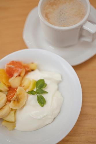 a plate of food with fruit and a cup of coffee at Hotel Uhland in Windhoek