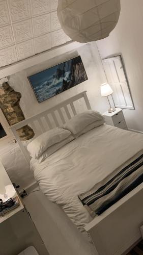 ein Schlafzimmer mit einem weißen Bett und einer Lampe in der Unterkunft Love Breeze Cottage 