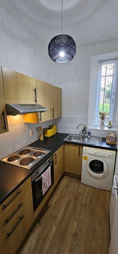 a kitchen with a sink and a stove and a dishwasher at Homestay in Aberdeen