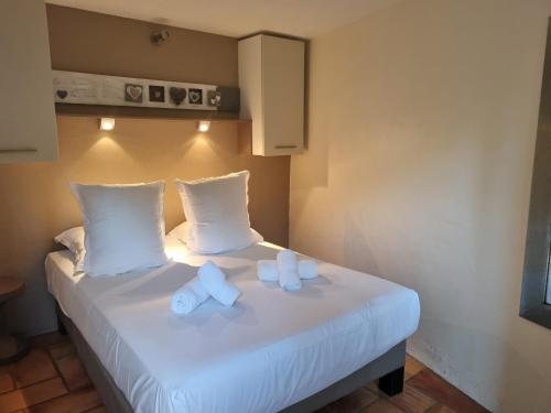 a hotel room with a bed with two white pillows at Les Garrigues de la Vallée des Baux in Paradou
