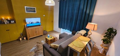 a living room with a couch and a tv at Homestay in Aberdeen