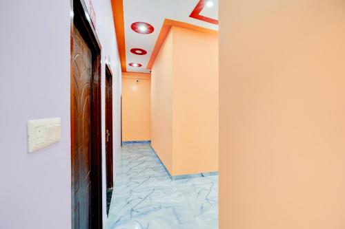 a hallway with orange walls and a tile floor at Hotel O ORM Inn in Bāra Banki