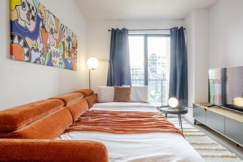 ein Wohnzimmer mit Sofa und Fernseher in der Unterkunft Modern Heritage Stay Upscale 2BR in Old Port in Montreal
