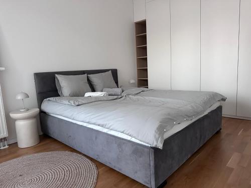 - un grand lit dans une chambre aux murs blancs dans l'établissement Mytna 50, à Bratislava