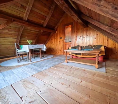 a room with a table and a bench in a cabin at Apartments Pajek & Pajčevina on the Hayrack in Dobje pri Lesičnem