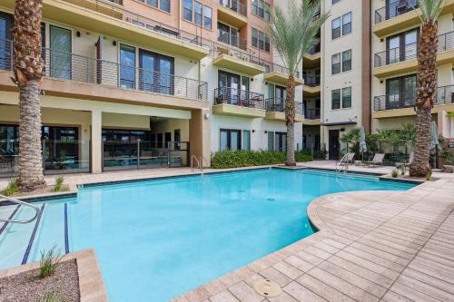 a swimming pool with palm trees in front of a building at Boulevard Stays Modern Roosevelt Row Suite 1BR Pool Gym 3 in Phoenix