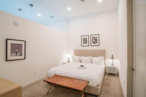 a white bedroom with a bed and a table at Boulevard Stays Modern Roosevelt Row Suite 1BR Pool Gym 3 in Phoenix
