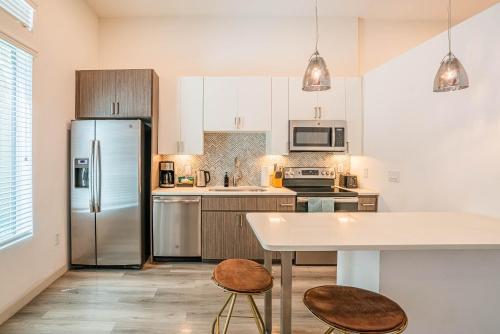 a kitchen with a refrigerator and a table and chairs at Boulevard Stays Modern Roosevelt Row Suite 1BR Pool Gym 3 in Phoenix