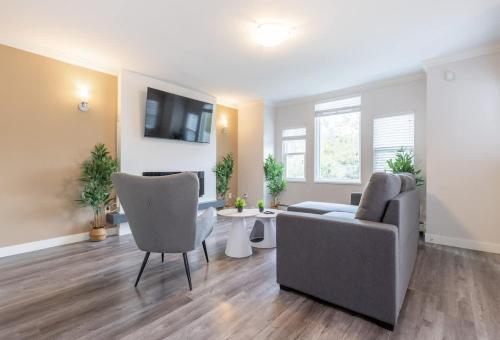 a living room with a couch and a chair at Soothing Minimalist Escape - Suite with Balcony & Fireplace in Vancouver