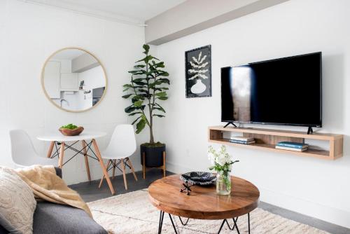a living room with a flat screen tv on a wall at ~The Abigail~ Rooftop / Skyline / Cozy in Atlanta
