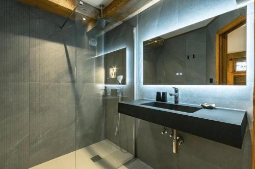 een badkamer met een wastafel en een spiegel bij CHALET TEKA LES GETS - Appartement Chery in Les Gets