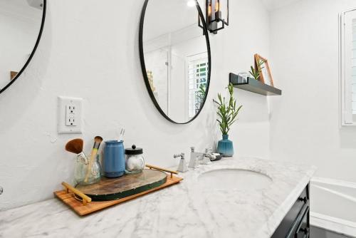 a bathroom with a sink and a mirror at Tranquil Oasis With Hot Tub, Near Dt & Beach Scene in West Palm Beach