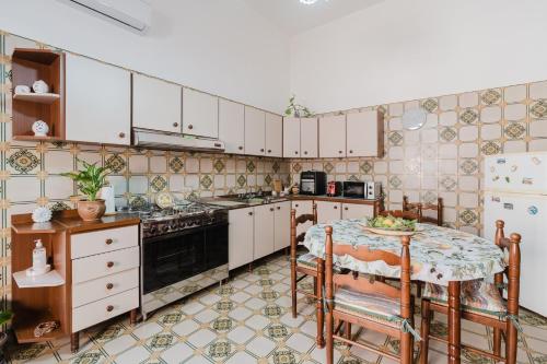 una cucina con un tavolo, un fornello e un frigorifero di Casa da Pino a Marsala