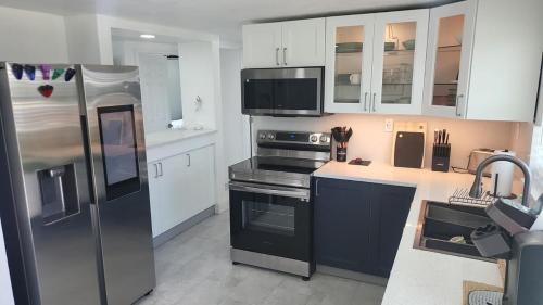 a kitchen with a stainless steel refrigerator and white cabinets at Lemon Tree Retreat in Hudson