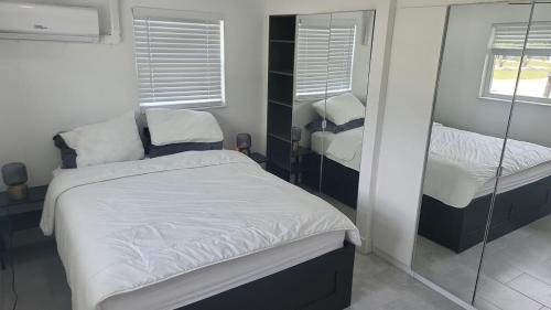 a small bedroom with two beds and a mirror at Lemon Tree Retreat in Hudson