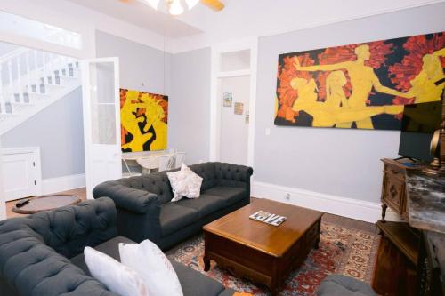 ein Wohnzimmer mit Sofa und Tisch in der Unterkunft Ursulines Historic Creole Mansion Steps to QTR Historic Getaways W Pool in New Orleans